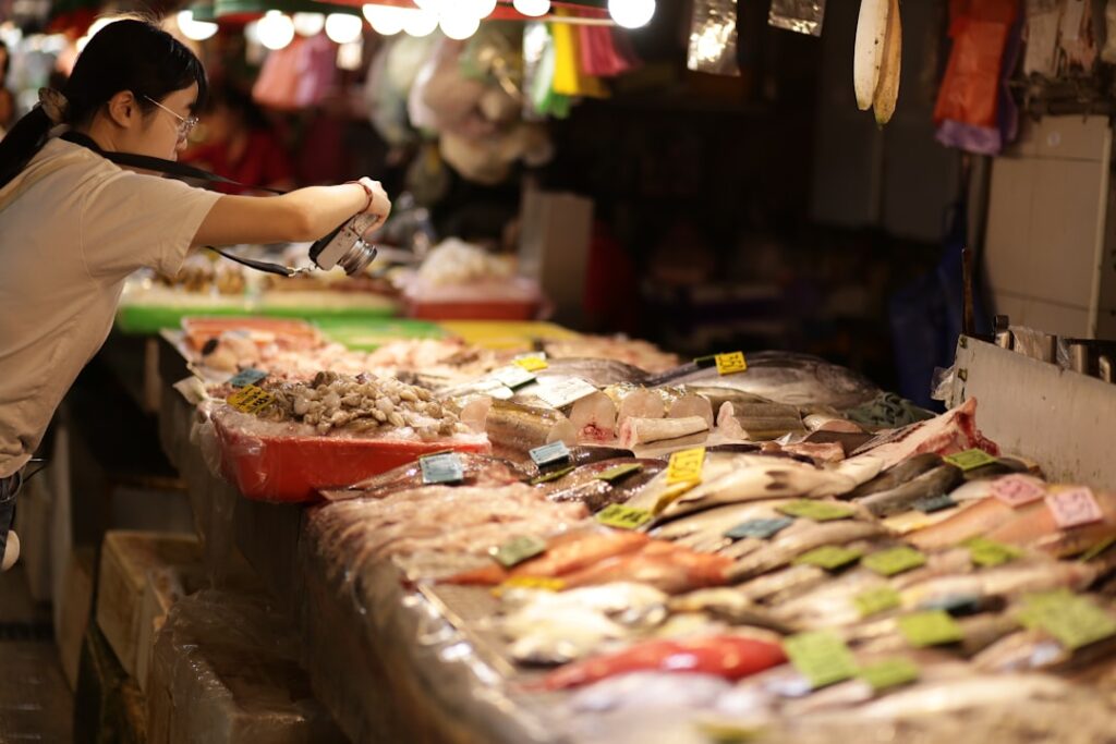 A person photographing fresh seafood at Split fish market stall