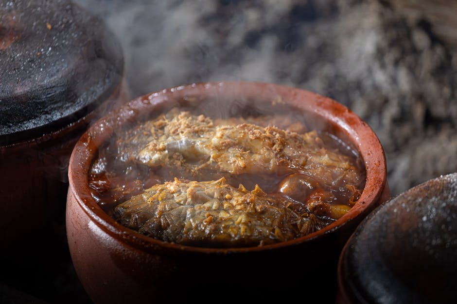 Stoomende aardewerken pot met gestoofde vis en saus in Split