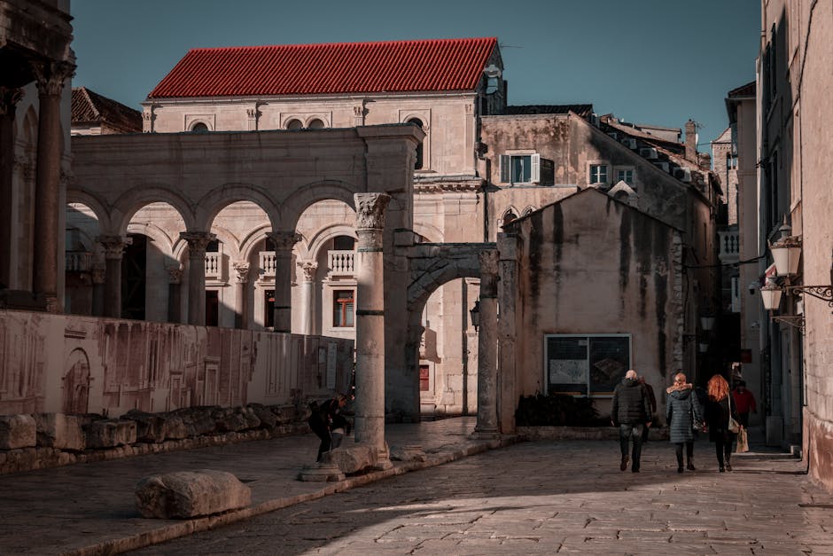People walking past ancient columns and arches inside Split's Diocletian Palace.