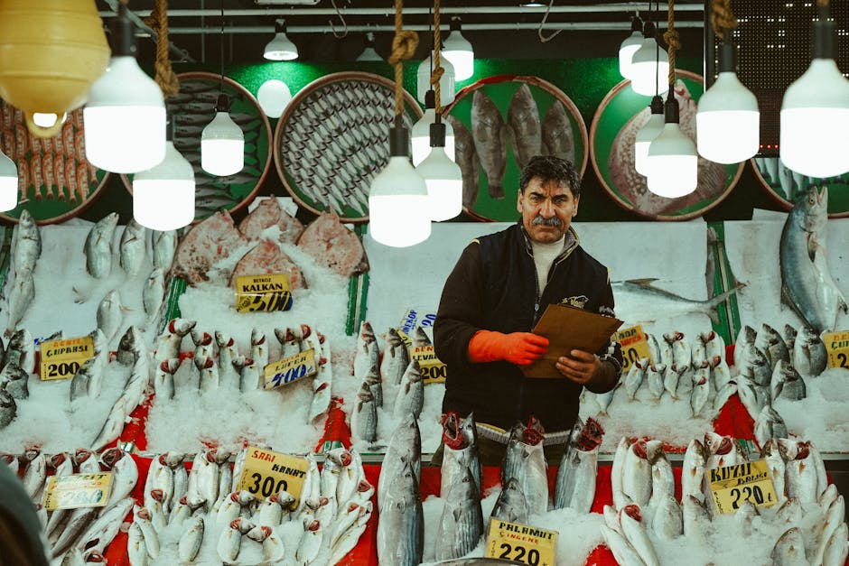 Viskraam met op ijs gelegde vis en verkoper op markt in Split