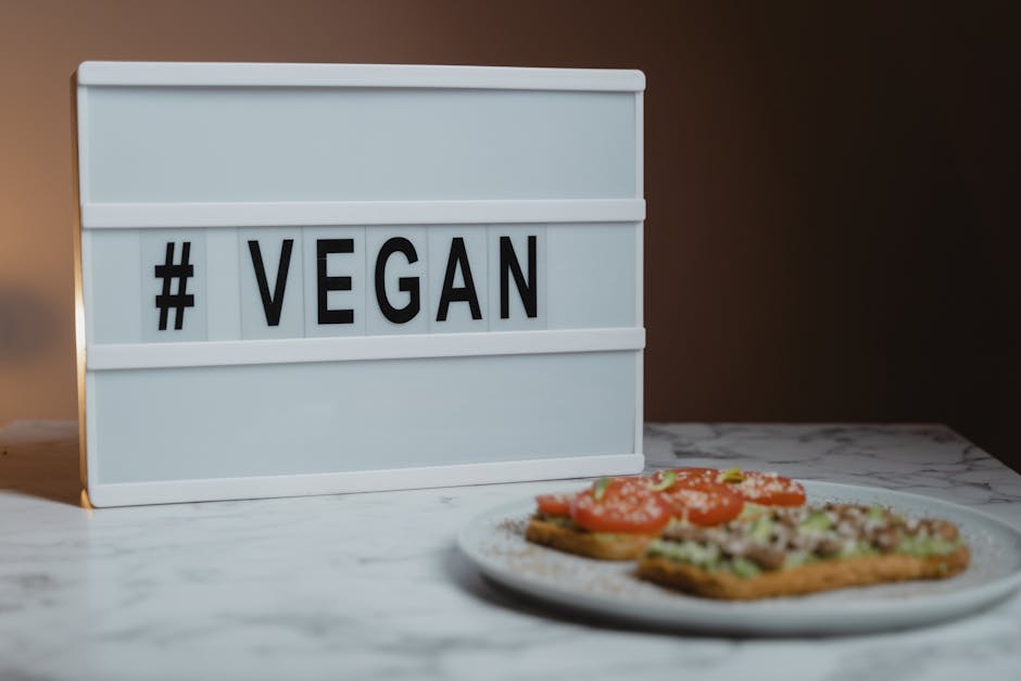 Wit lichtbord met #VEGAN en vegan broodjes op tafel