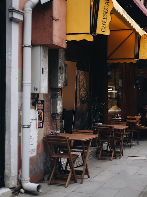 Kleine straatterrasjes met houten tafels onder gele luifel in Split.