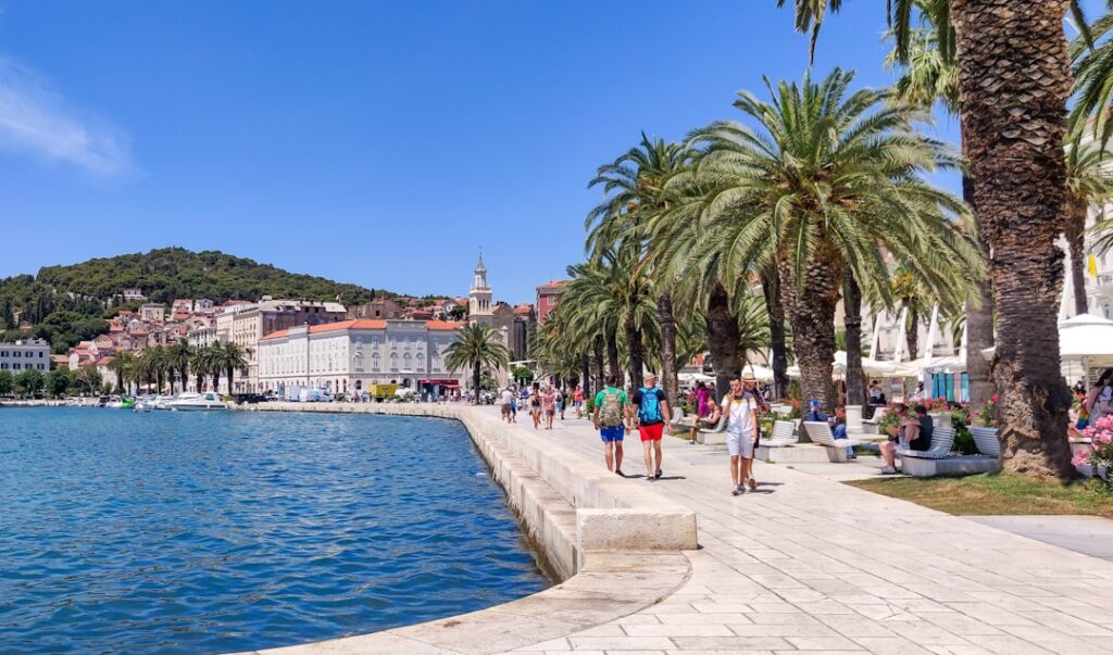 Palmen und Promenade der Riva in Split mit Spaziergängern