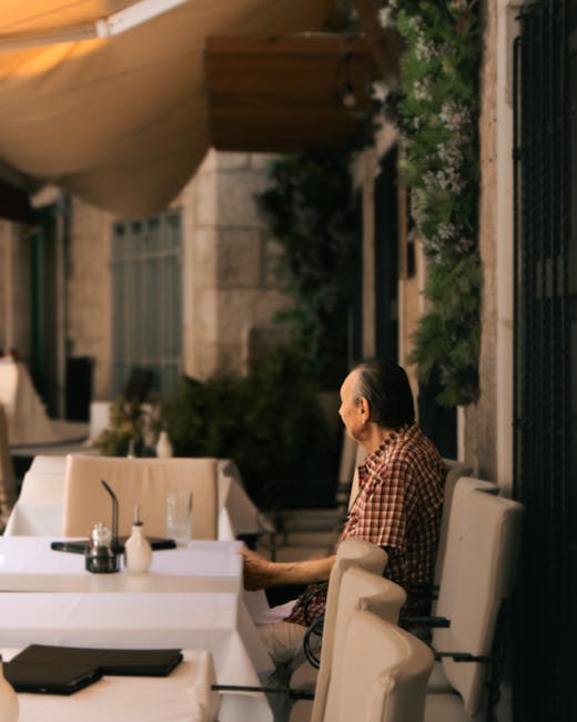 Elderly man seated at quiet Split café terrace beside empty tables