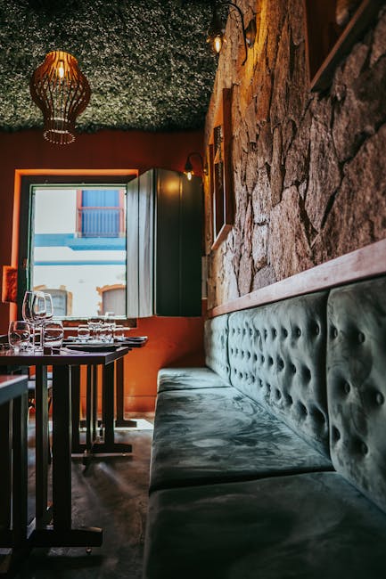 Cozy Split restaurant interior with green velvet banquette and stone wall