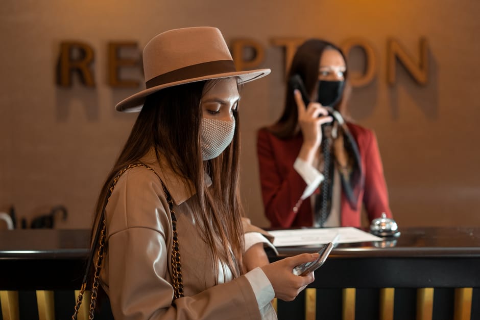 Reisender prüft Hotelbuchungsbestätigung auf dem Handy in einem Café