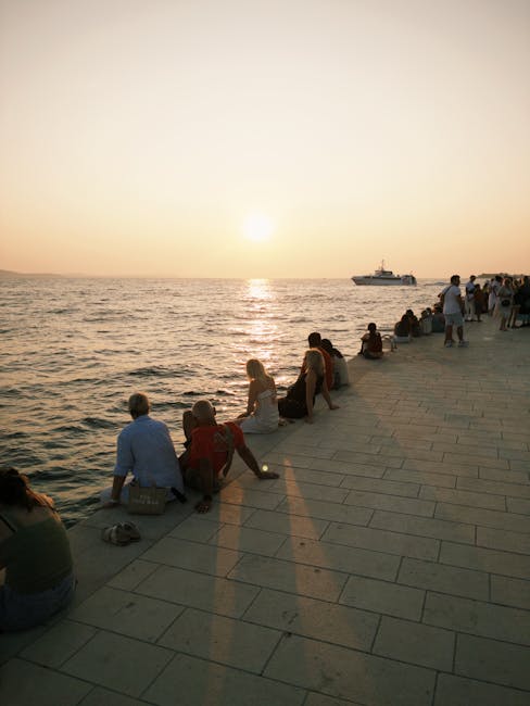 Tramonto sulla passeggiata di Zadar con persone che godono dell'Organo Marino e delle luci