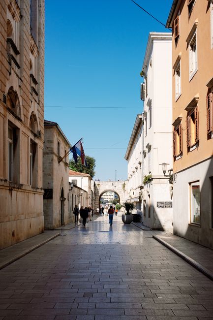 Vicoli in pietra del centro storico di Zara al tramonto con il Sea Organ in vista