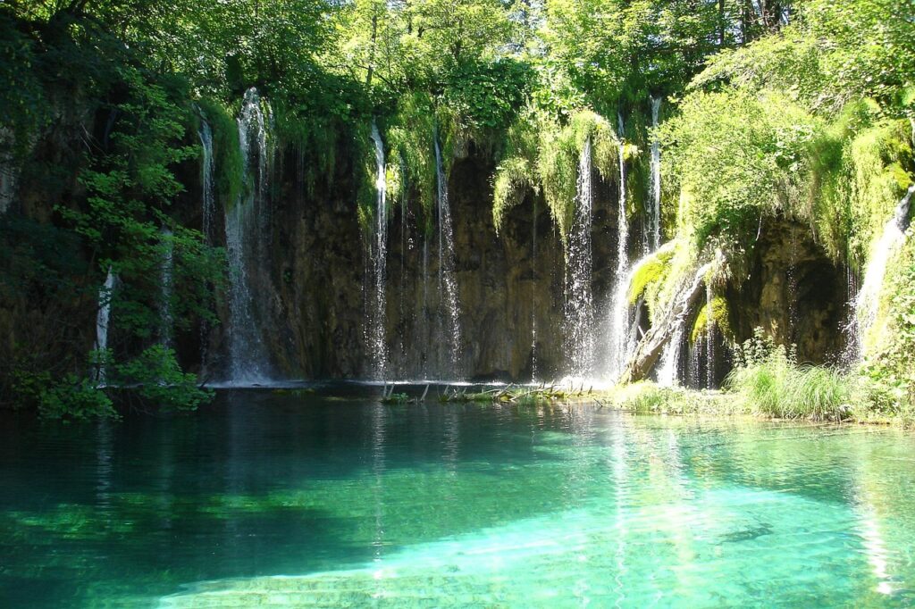 Passerella di legno sui Laghi di Plitvice sopra acqua turchese in una giornata di sole