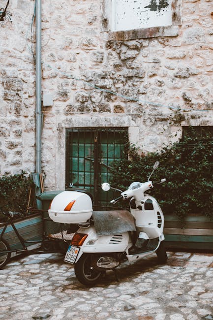 Scooter parked near Hvar old town stone alley with helmet