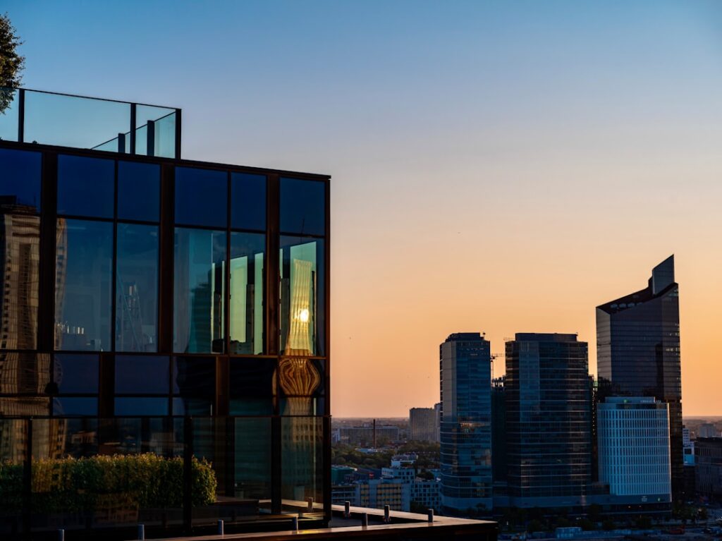 Rooftop bar di un hotel moderno con skyline cittadino al tramonto
