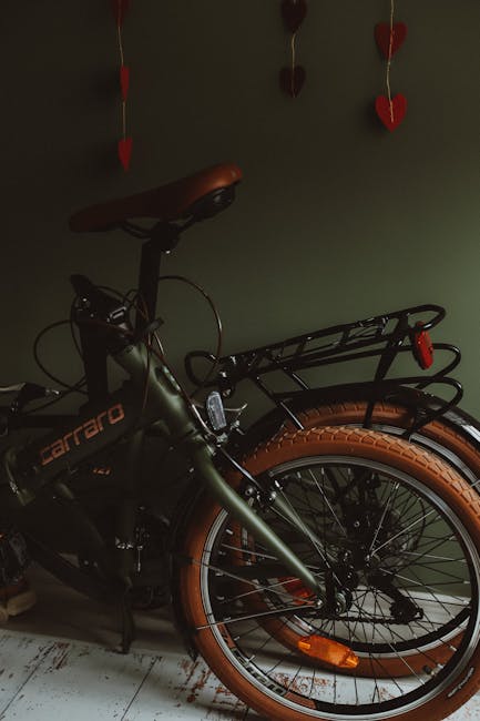 Bici pieghevole appoggiata a un muro verde a Barcellona