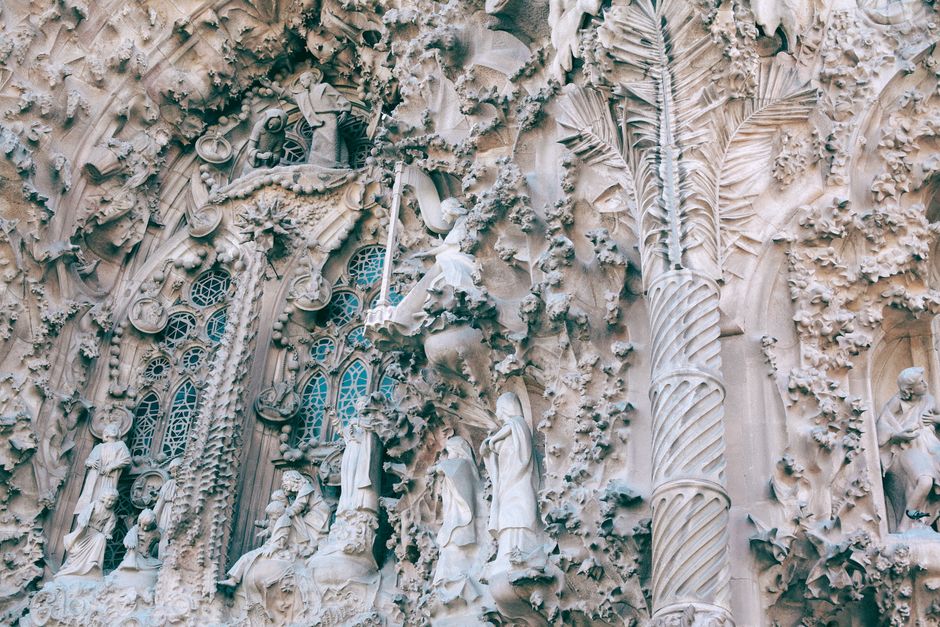 Close-up van gebeeldhouwd steenwerk op de Nativiteitsgevel van de Sagrada Família, fijne figuren