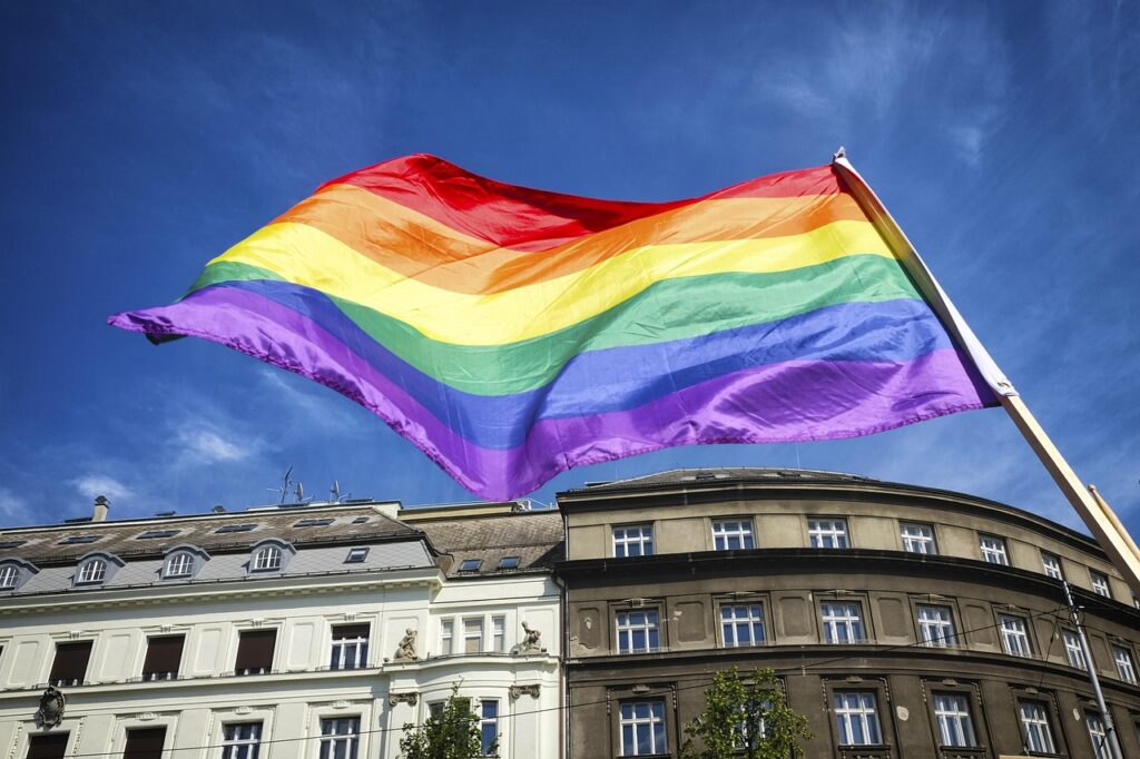 Strada affollata a Chueca con bandiere arcobaleno di sera