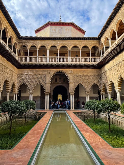 Cortile soleggiato del Real Alcázar con turisti