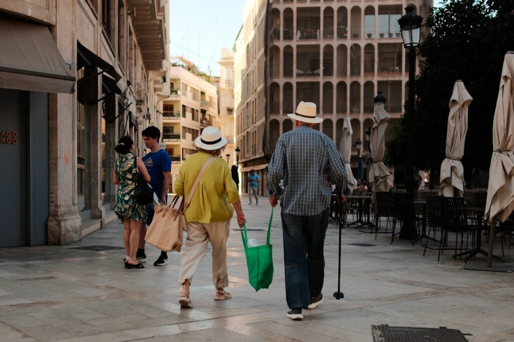 Strada di Valencia con borse della spesa e clienti al tramonto