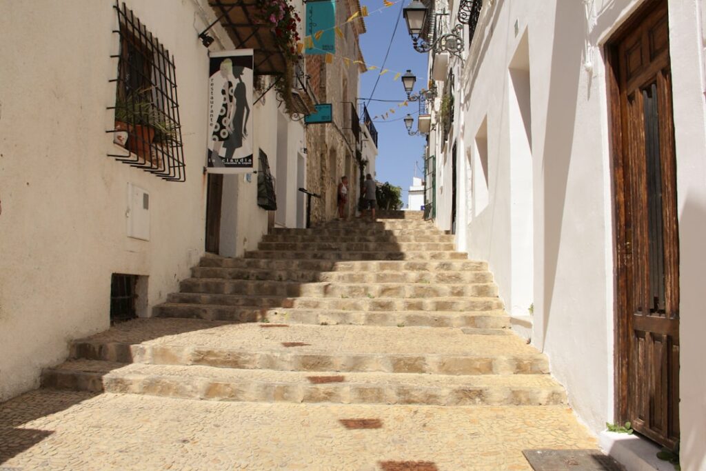 Narrow Albaicín street with sunlight on tiled steps