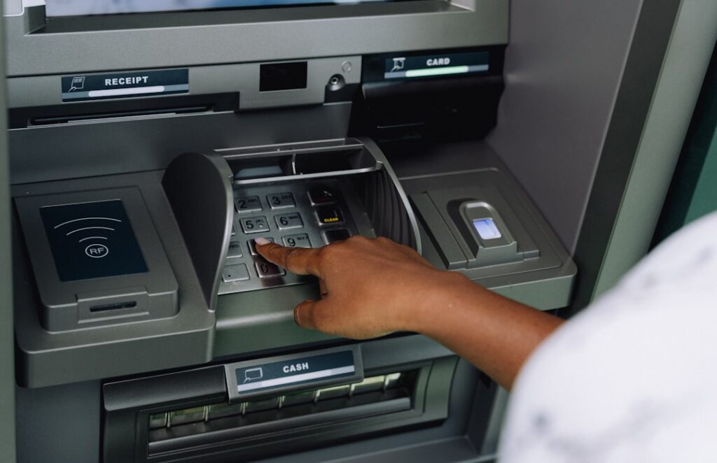 Traveler using an ATM inside a bank for a safe withdrawal