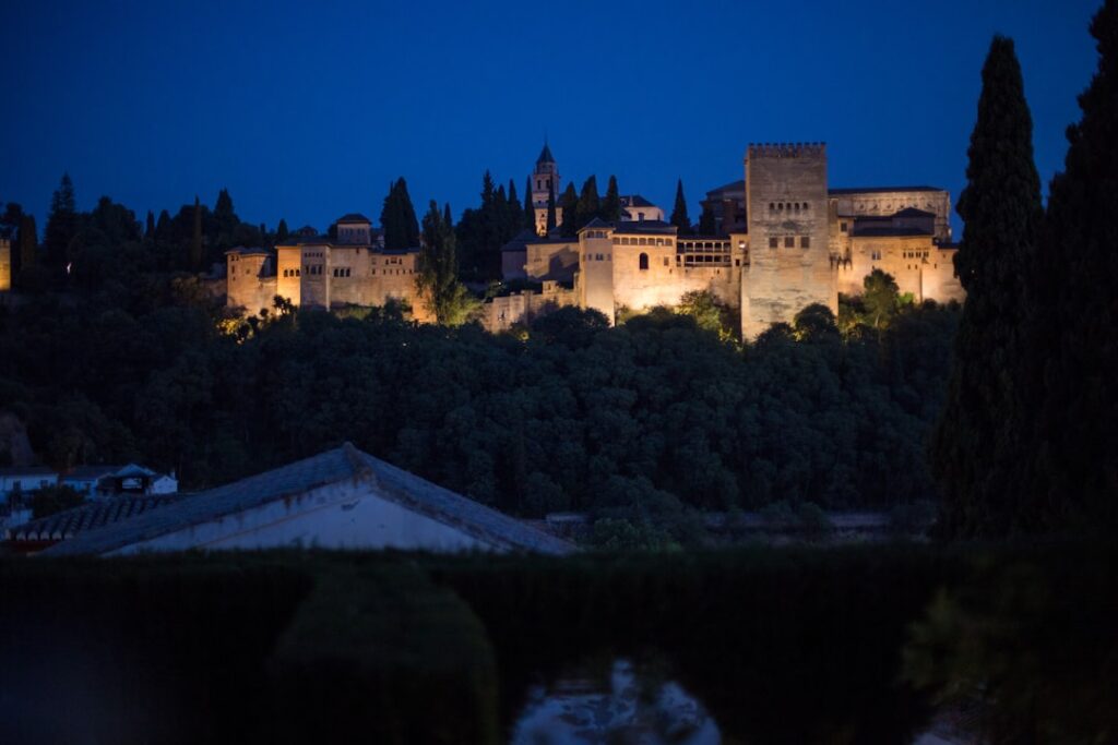 Alhambra lit up at night viewed from a mirador