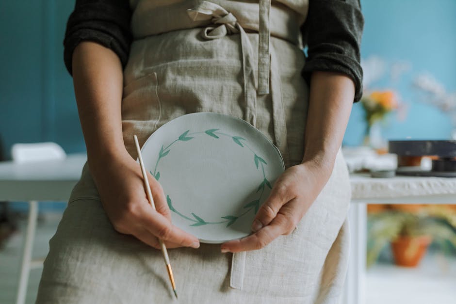 laboratorio di ceramica con mani che dipingono pezzi colorati