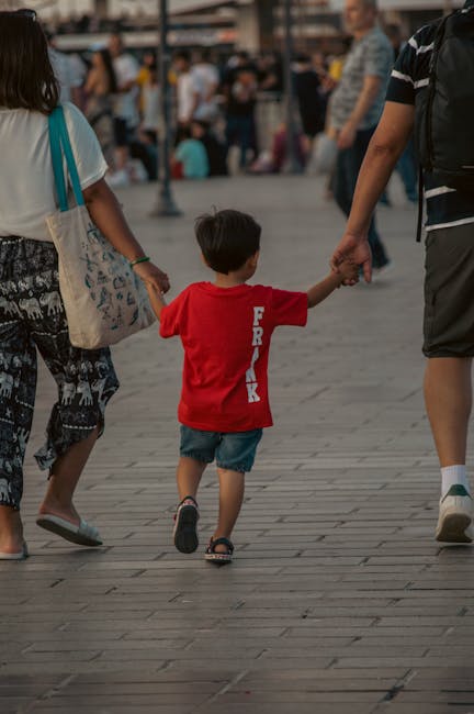 famiglia che cammina per una strada acciottolata di Granada con bambini per mano