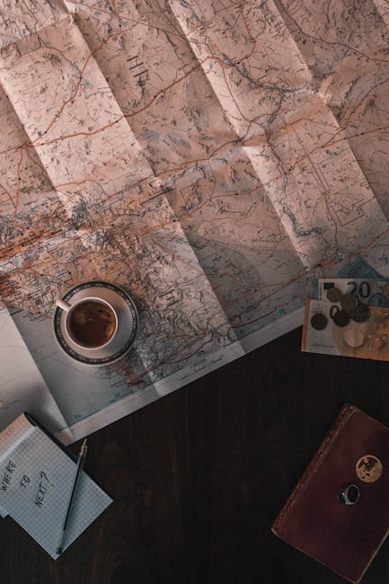 taccuino budget viaggio, monete e mappa locale sul tavolo