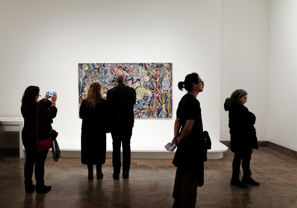 Visitatori che osservano una grande opera contemporanea in galleria