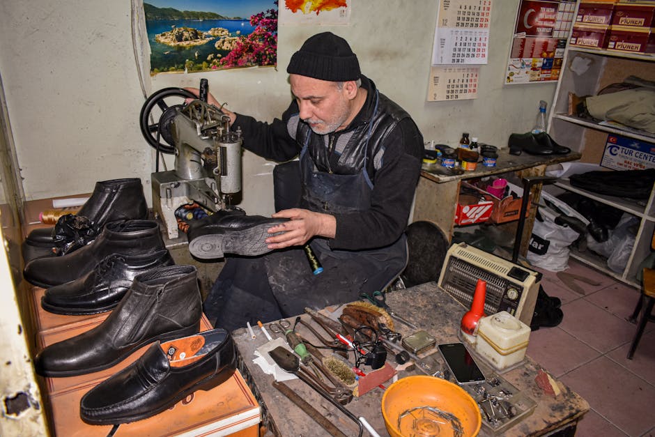 Calzolaio artigiano che ripara scarpe in un piccolo laboratorio