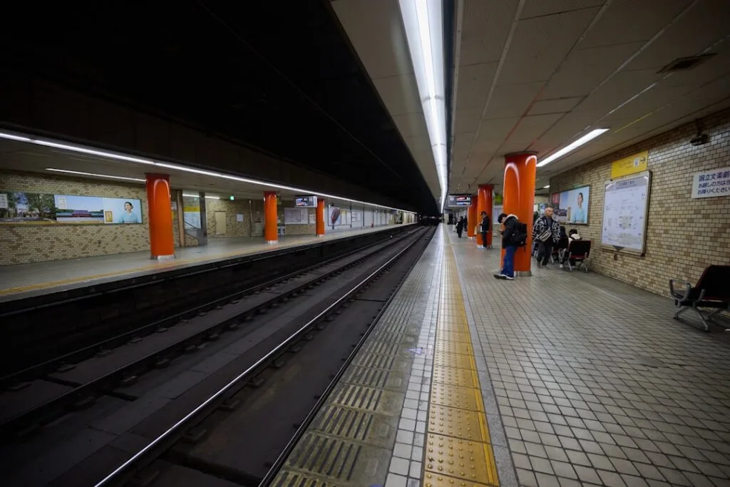 Empty underground metro platform with orange columns and tiled floor