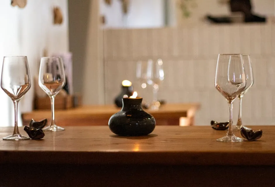 Wine glasses and a small candle on a wooden table at a Porto venue