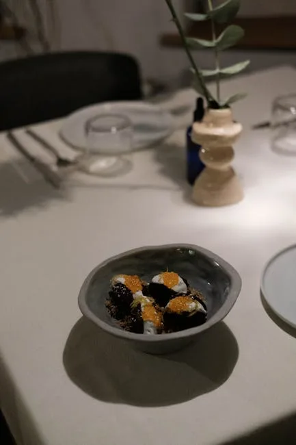 Small plated appetizer in dimly lit Porto restaurant with a vase.