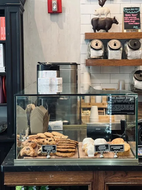 Glass display case holding assorted cookies and pastries behind a counter in Porto