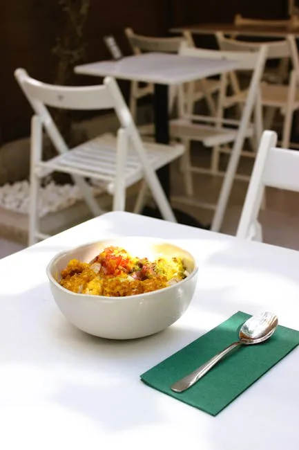 White bowl of savory gluten-free dish on table with spoon in Porto café