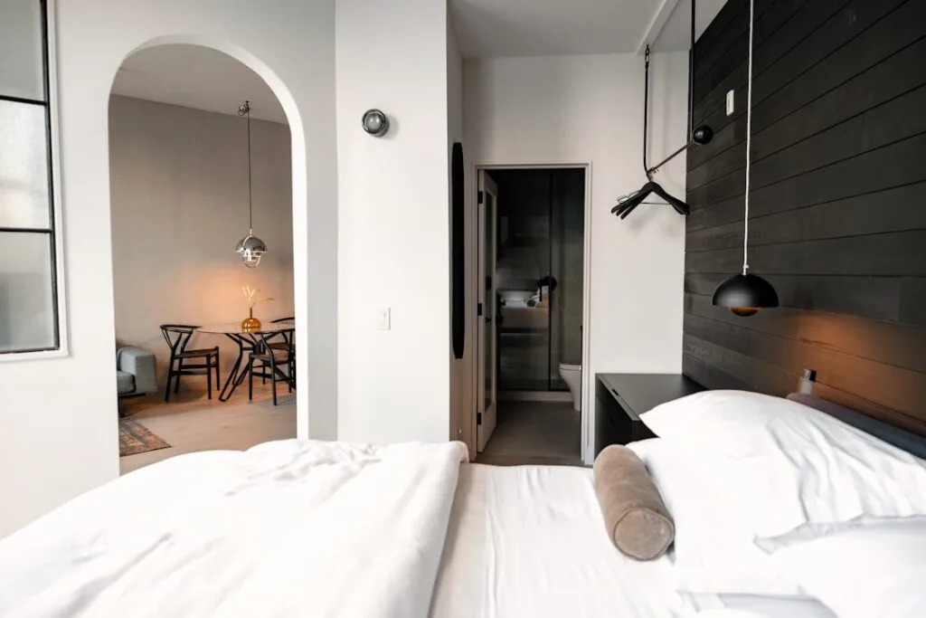 Minimalist double bed room with arched doorway and dining area in a Porto stay