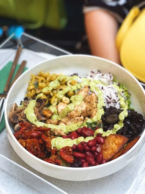 Vibrant vegan grain bowl with rice, beans, mushrooms, and avocado crema