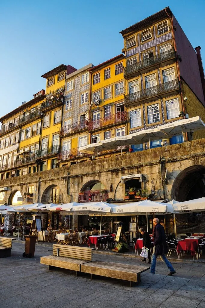 Colorful riverside buildings and outdoor cafes with umbrellas in Porto