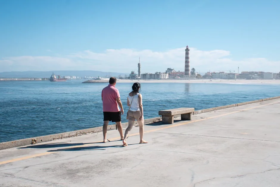 Couple walking along Porto waterfront pier with distant lighthouse view