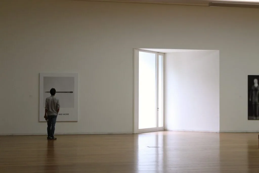 Visitor viewing minimalist artwork inside a bright Porto museum gallery room