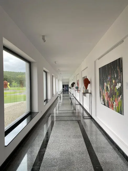 Bright Serralves gallery corridor with windows overlooking gardens and sculptures