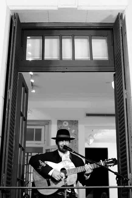 Black-and-white portrait of a guitarist singing from a Porto balcony