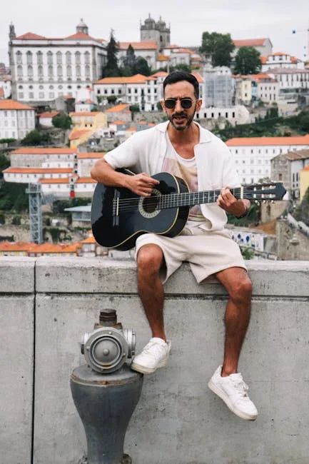 Man playing guitar on a stone balustrade with Porto skyline