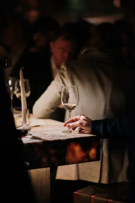 Hand holding a wine glass at a dimly lit Porto fado venue candlelit table