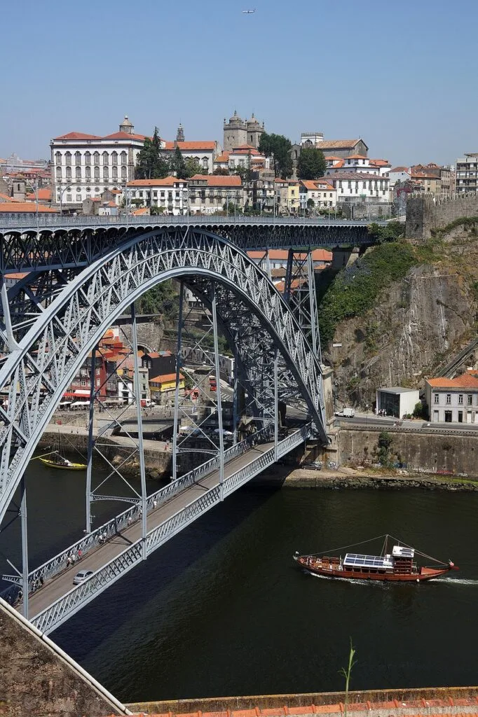 Dom Luís I Bridge arch in Porto spanning the Douro with boat