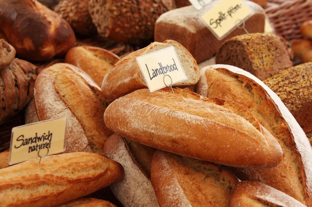 Close-up of rustic loaves labeled at a Porto market bakery stall