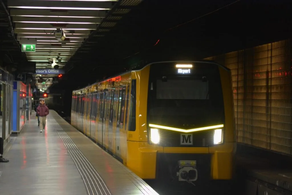 Yellow metro train at an underground Porto platform bound for Airport