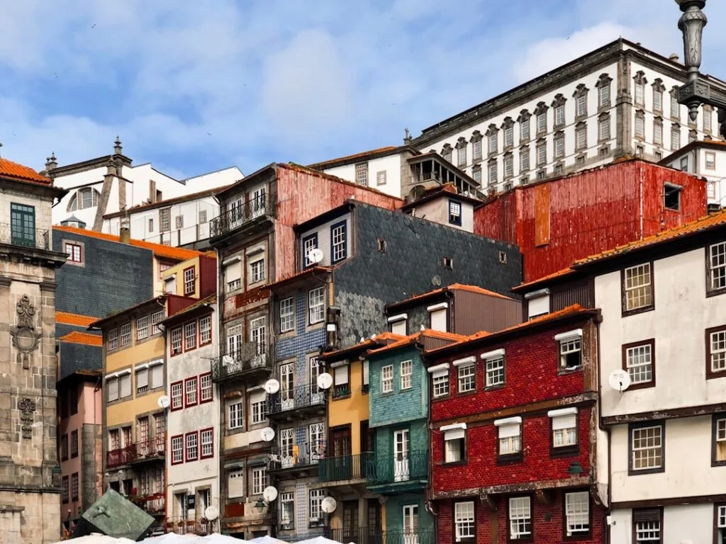 Narrow street in Porto with colorful buildings and walking tourists