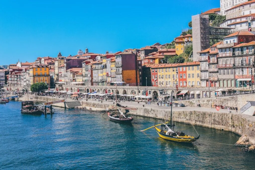 Colorful Ribeira waterfront buildings and rabelo boats along Douro in Porto