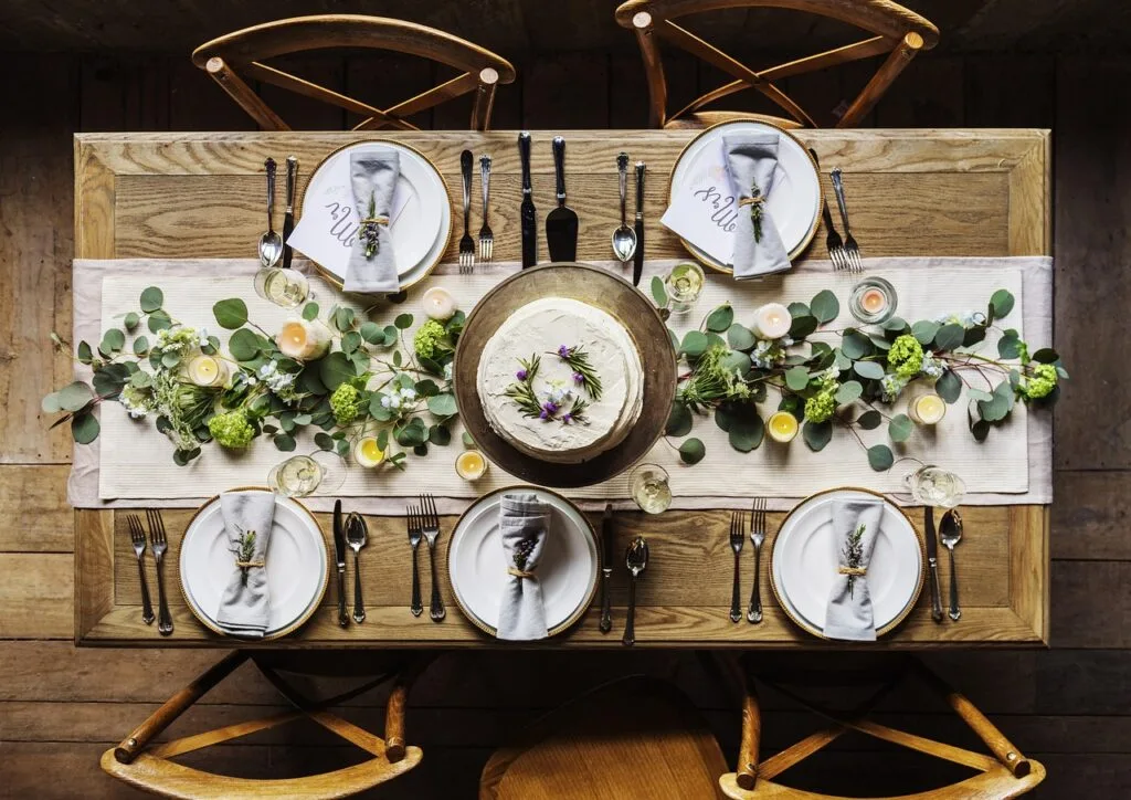 Rustic wooden table set for six with a decorated cake centerpiece