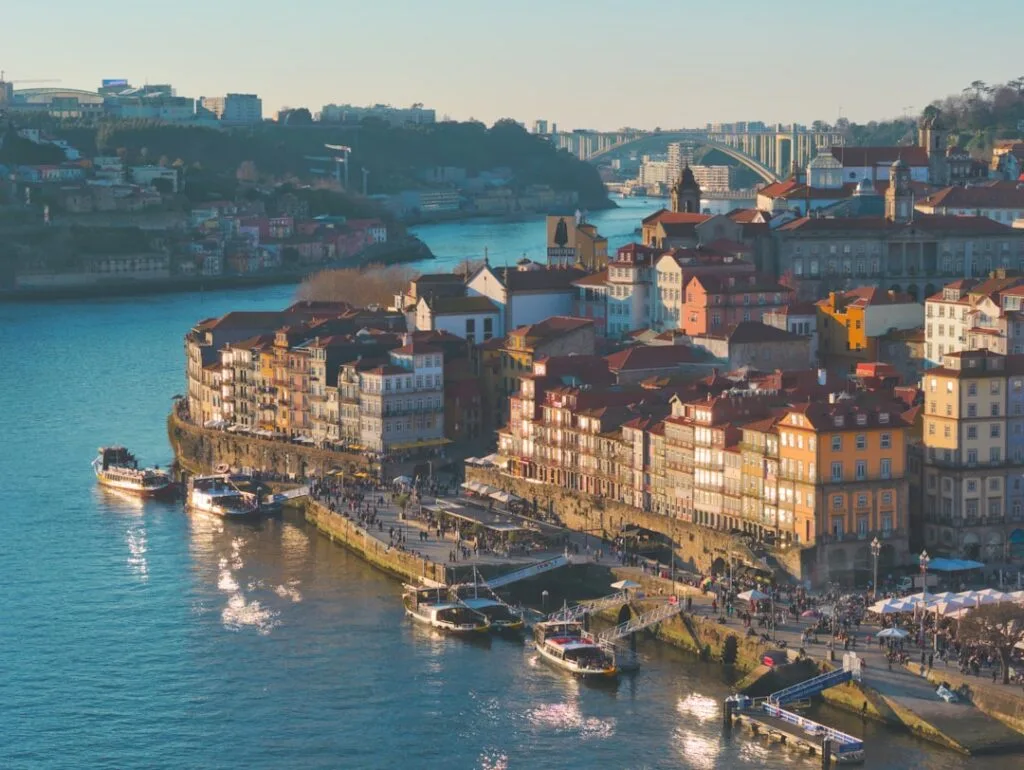 Colorful Ribeira buildings along the Douro River with moored boats, Porto