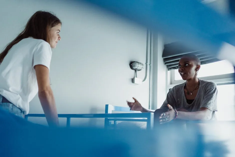 Two guests talking beside blue bunk beds inside a hostel